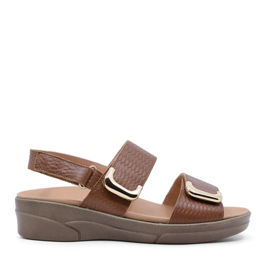caramel brown print leather velcro sandal with a buckle strap and a flat sole.