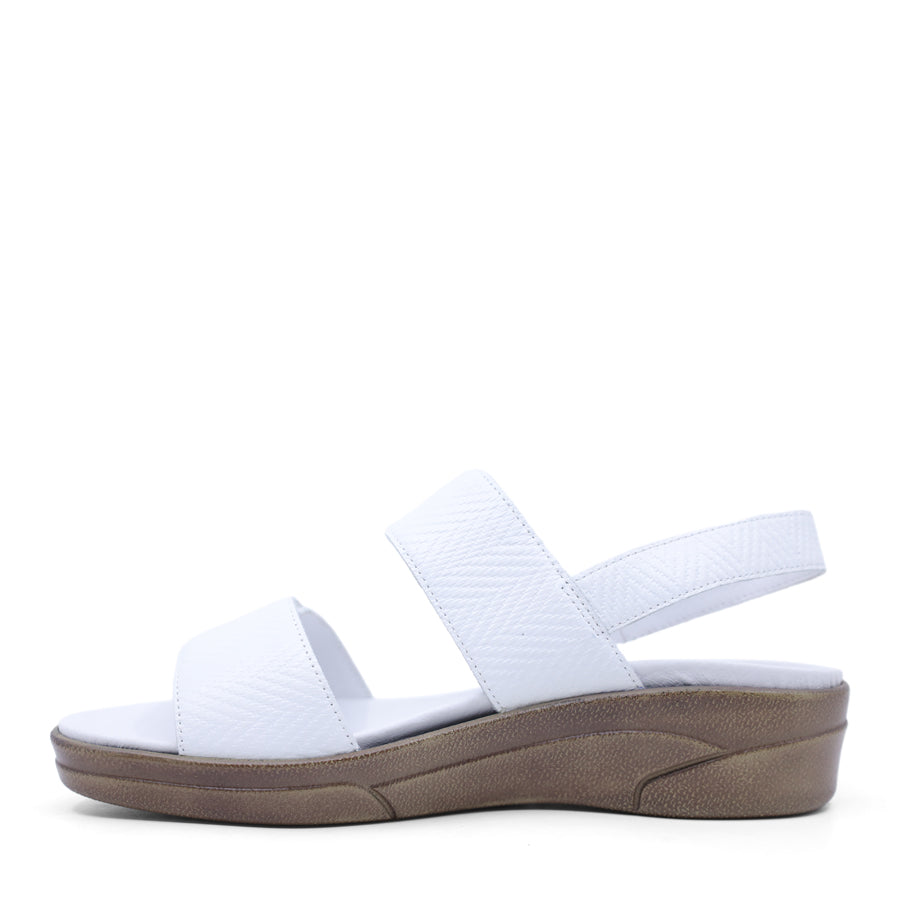 white print leather velcro sandal with a buckle strap and a flat sole.