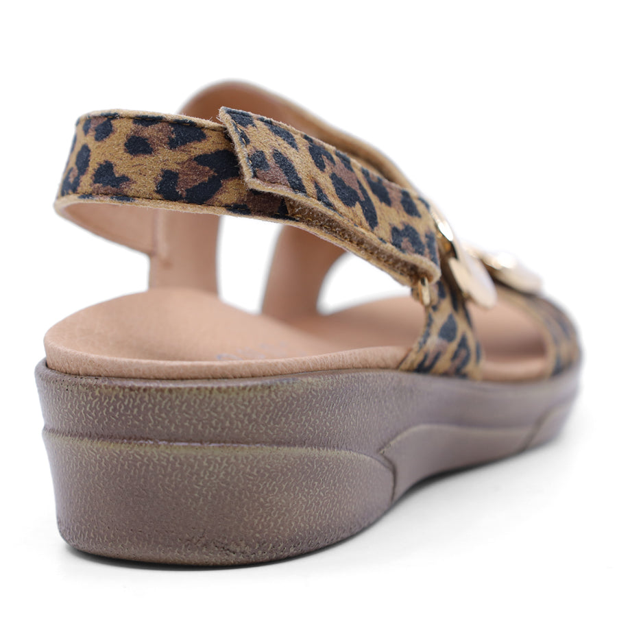 brown leopard print leather velcro sandal with a buckle strap and a flat sole.