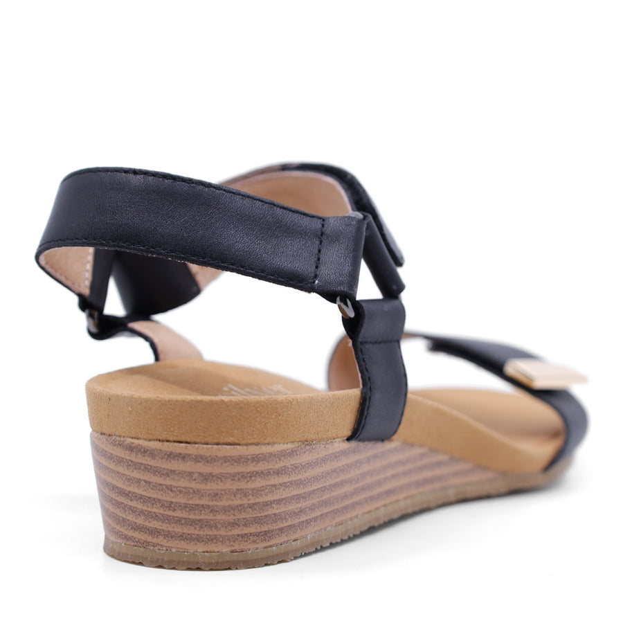 black wedge sandal with a wooden wedge sole and velcro strap