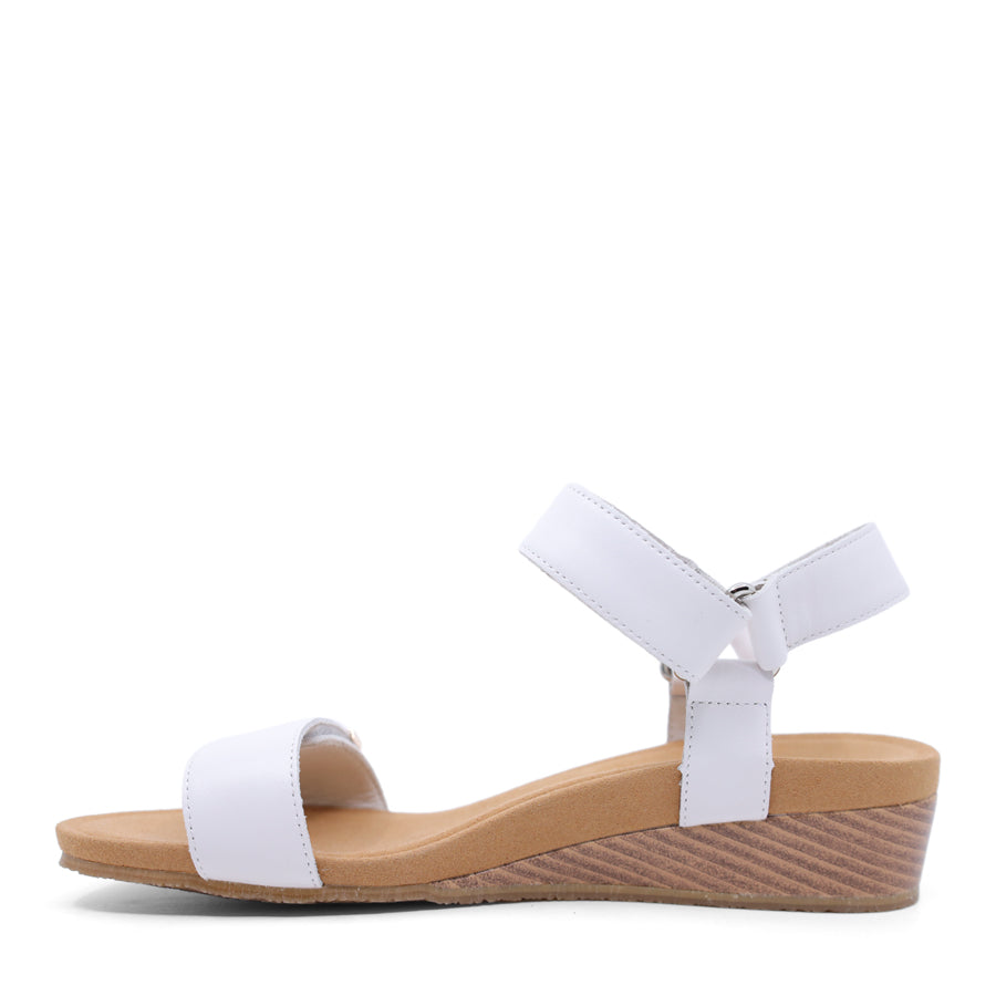 White wedge sandal with a wooden wedge sole and velcro strap